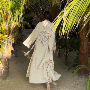 A women in a snake kimono walking through a tropical setting with palm trees
